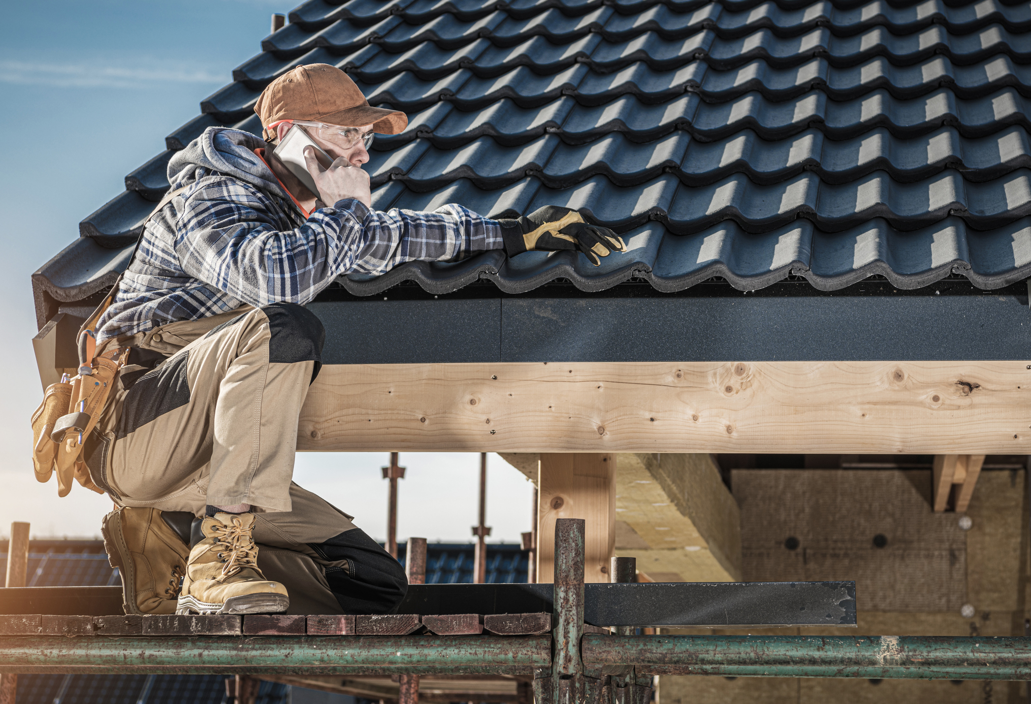 Roofer answering client call while working